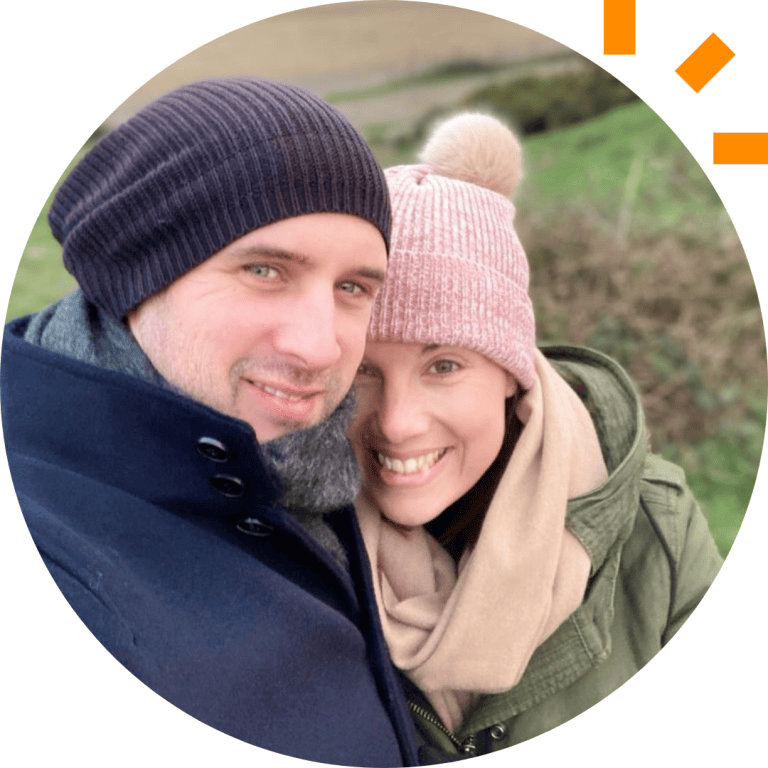 A picture of Amy and her husband standing outside