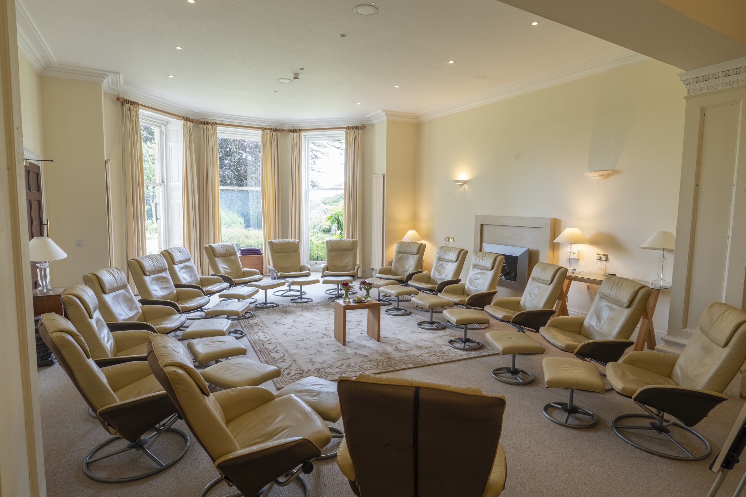 A bright lounge at the Penny Brohn Cancer Care Centre, with reclining chairs set in a circle