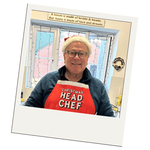Paul at home at Christmas, wearing a Christmas head chef apron